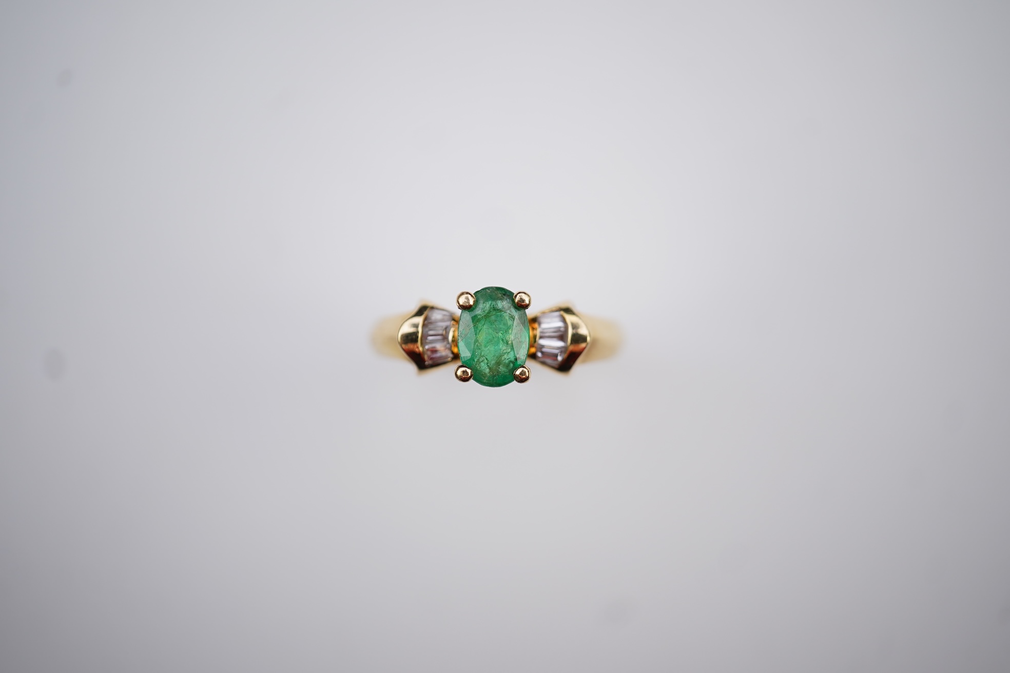 An emerald and diamond ring